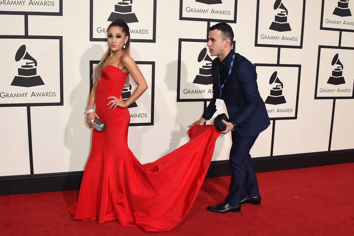 Ariana Grande posa mientras le arreglan el vestido. FOTO AP