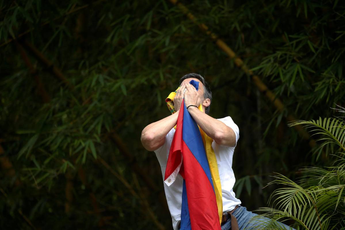 Algunas horas después, López se asomó a saludar a sus partidarios desde los muros del recinto de su residencia mientras ondeaba una bandera venezolana. FOTO REUTERS