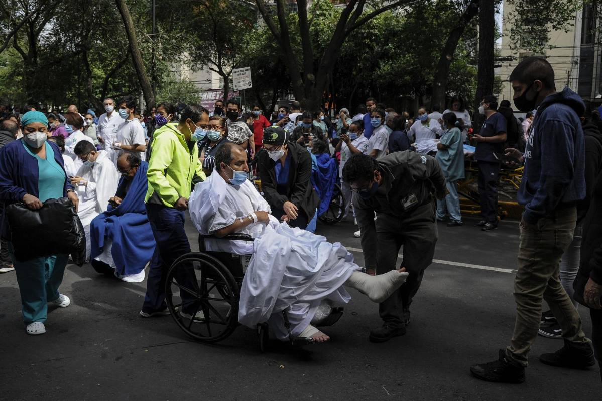 Médicos y pacientes, incluso en camillas y sillas de ruedas, se vieron obligados a evacuar las instalaciones de la Clínica Durango en Ciudad de México. FOTO AFP