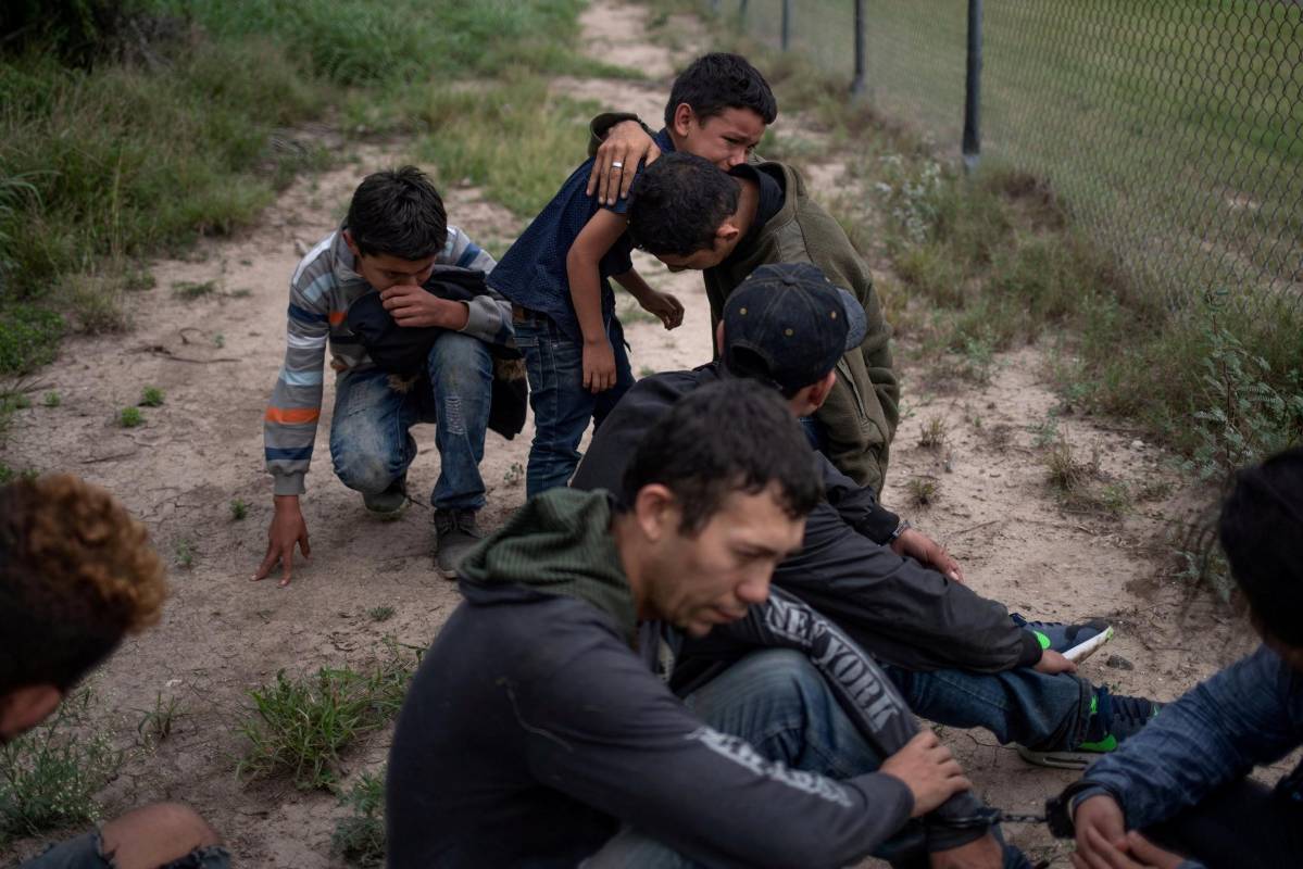 Un niño de cuatro años llora en los brazos de sus familiares. Fueron arrestados por agentes que patrullaban el borde entre México y Estados Unidos, cerca a Texas. Trataban de entrar ilegalmente. Foto: Reuters 