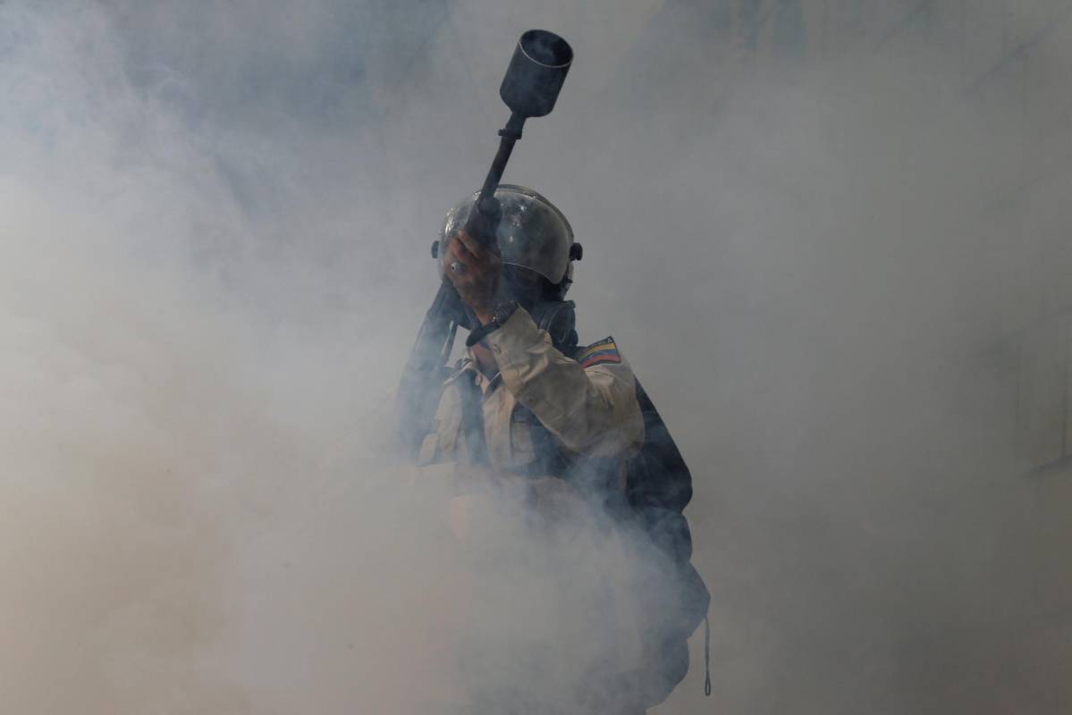 Agentes de la policía entre gases lacrimógenos que disparan a manifestantes. REUTERS