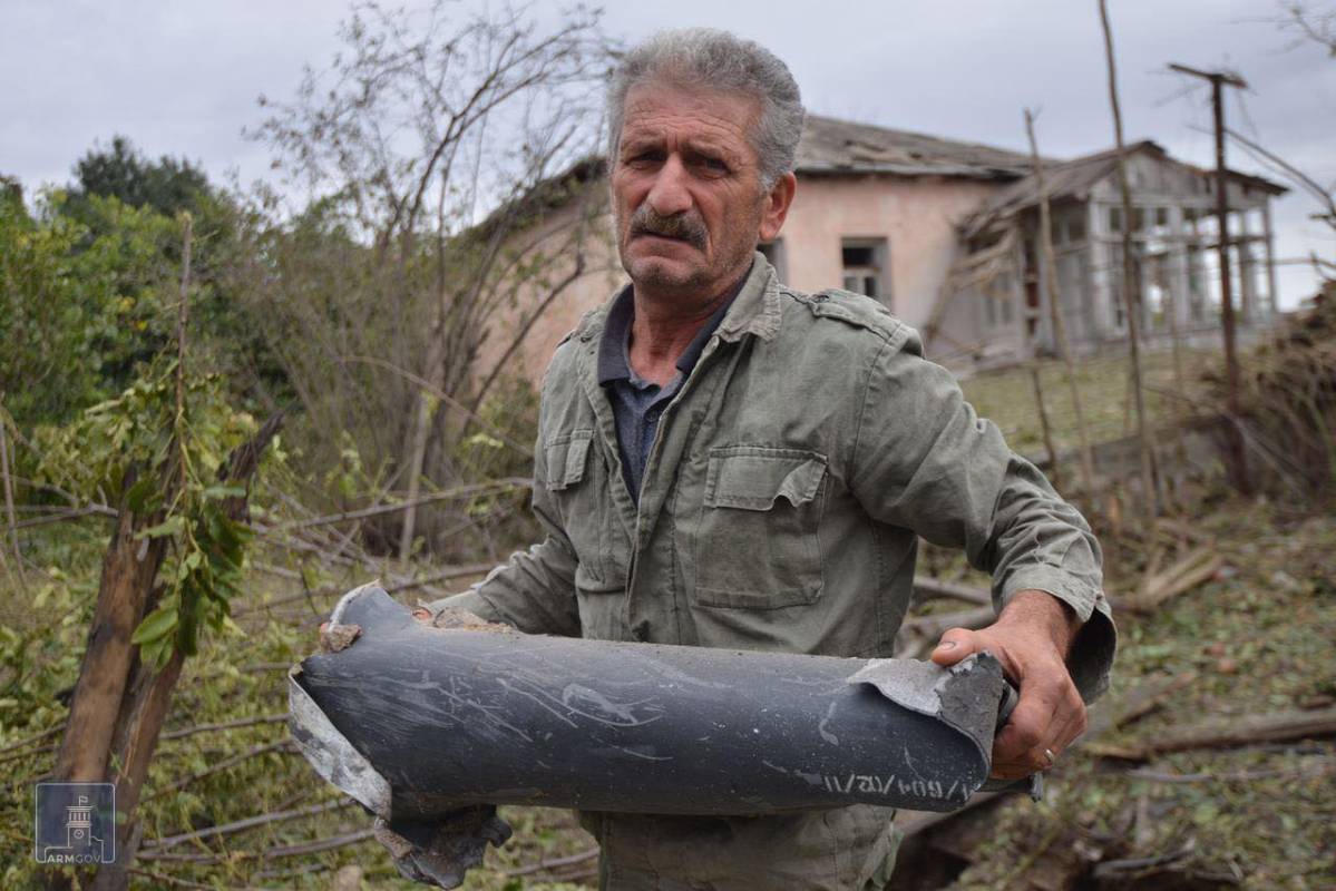 Un hombre sostiene un fragmento de munición tras lo que se dice que fue un ataque azerí durante los enfrentamientos entre los separatistas armenios y Azerbaiyán Foto: AFP