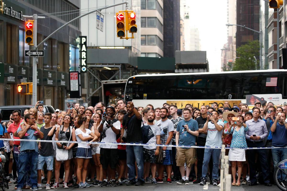 La gente que desde la calle contigua a la edificación, propiedad de Donald Trump, observa al muchacho. FOTO Reuters