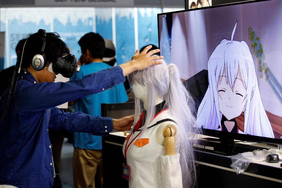Un hombre toca un maniquí mientras intenta salir del sistema “E-mote” de un M2 Co.Ltd . “e-mote “es la abreviatura de” Tecnología de movimiento emocional. FOTO Reuters