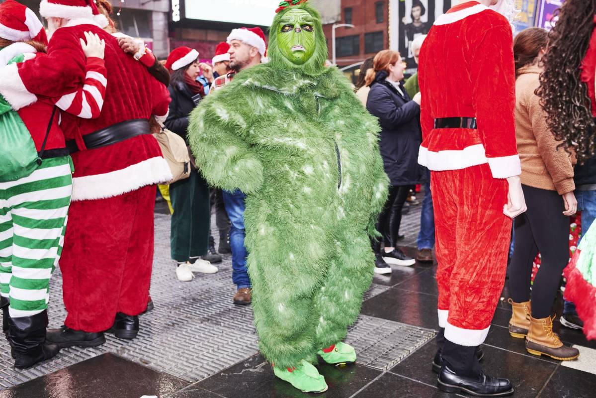 El Grinch, quien odia la Navidad, estuvo presente entre los Santa Claus. Foto GABBY JONES - Efe 
