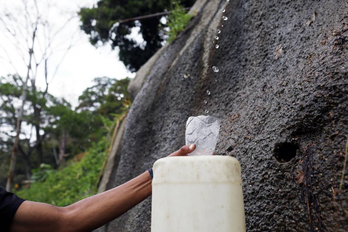 Un hombre llena un tanque con agua que viene de la montaña en Caracas, Venezuela. Foto: Manaure Quintero