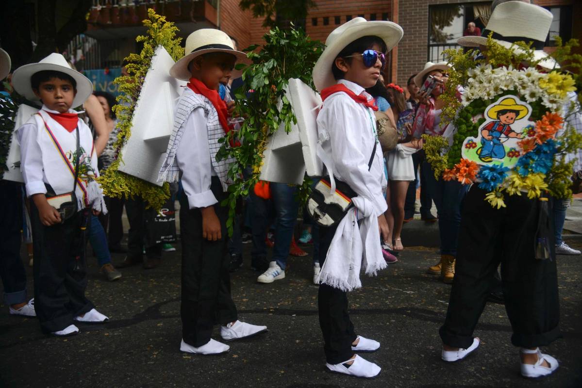 Niños de entre 4 y 11 años de edad exhibieron pequeños arreglos florales que cargaron en sus espaldas con mensajes alusivos a la conservación del medio ambiente, los valores y el fútbol. FOTO AFP