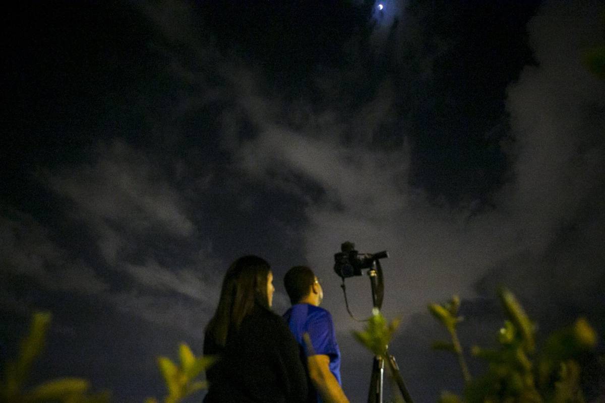 Esta pareja en Caracas, Venezuela buscaba la mejor toma de la Luna roja. FOTO Reuters/Marco Bello