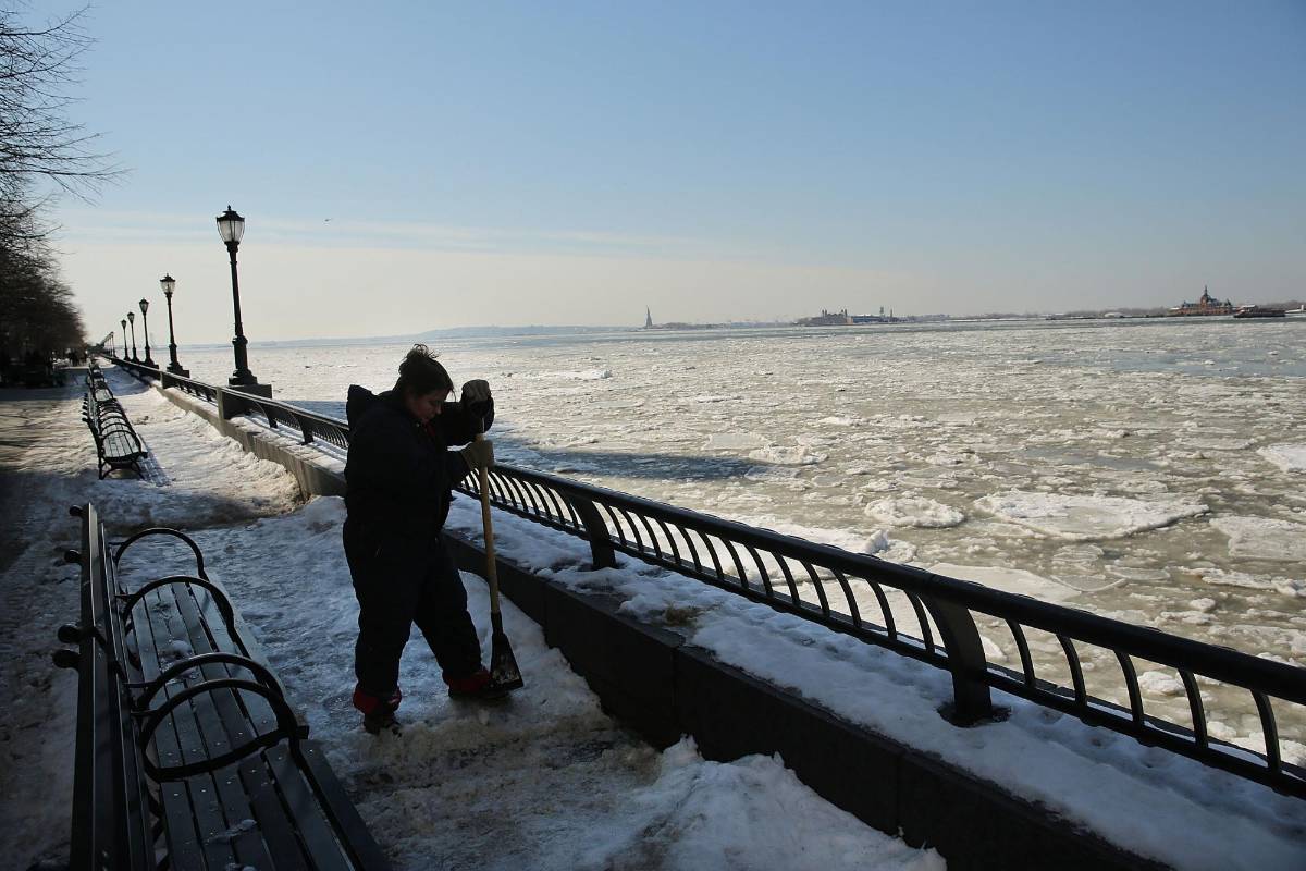 Trabajadores tratan de limpiar la nieve. FOTO AFP