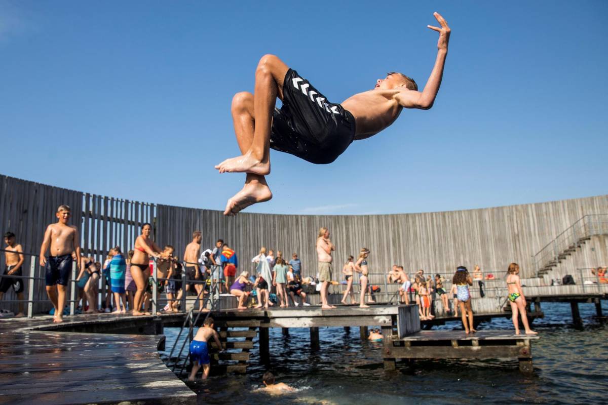 Varias personas combaten un día caluroso en la plataforma de baño de Amager, en Copenhague (Dinamarca). Foto: EFE