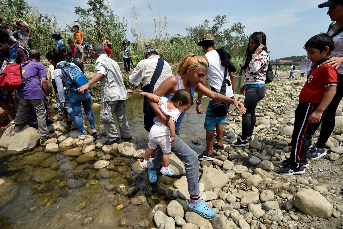 La gente cruza por trochas a través del río Táchira, cerca del puente internacional Simón Bolívar. Foto AFP