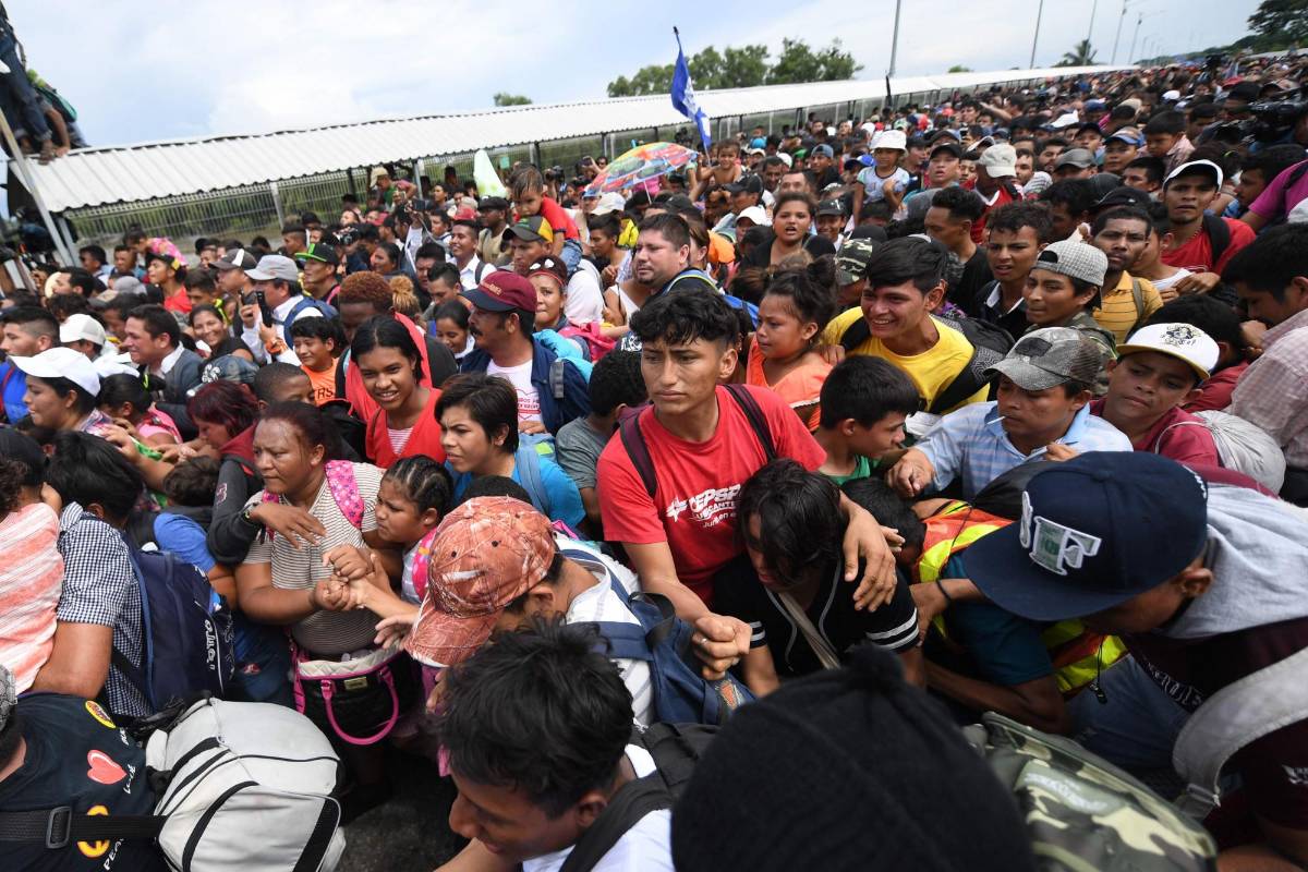 Miles de migrantes hondureños, que salieron en caravana de su país con destino a Estados Unidos, viven una tensa espera en el puente fronterizo entre México y Guatemala. AFP