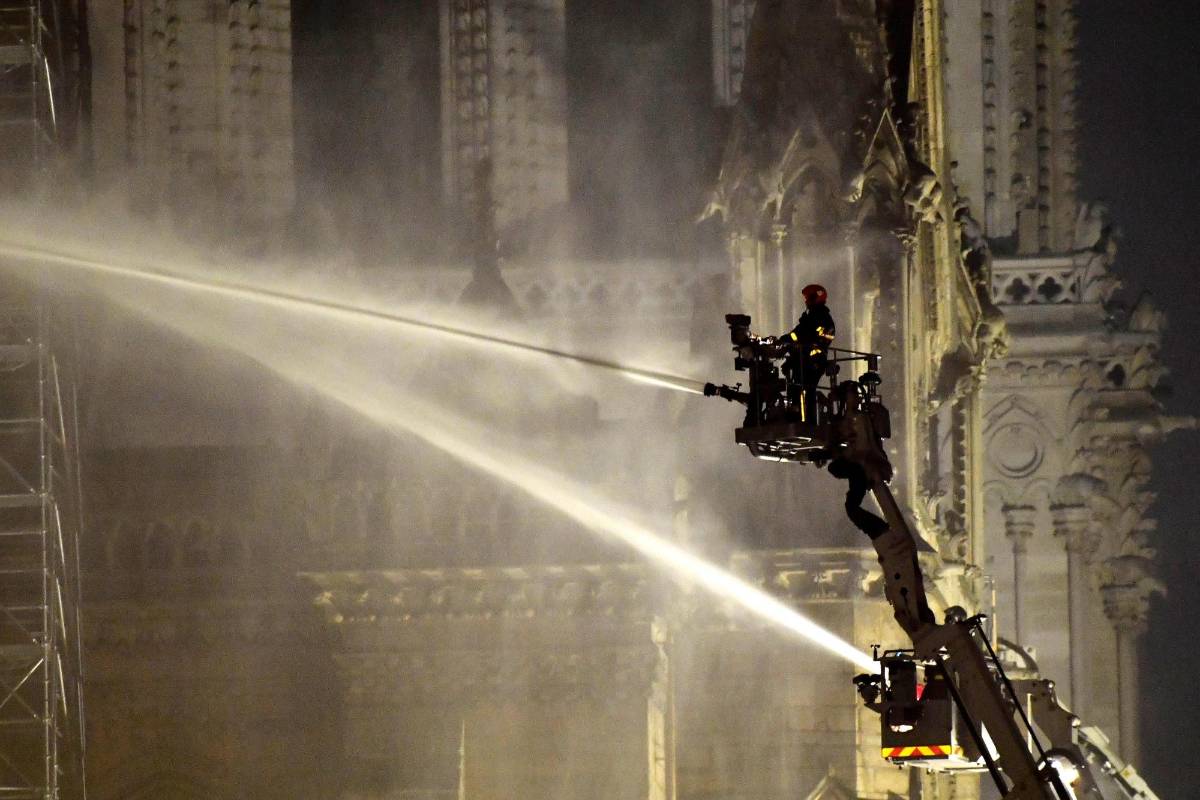 Los funcionarios de la iglesia corrieron para intentar salvar las pinturas y otros tesoros culturales, antes de ser evacuados por los bomberos. FOTO EFE