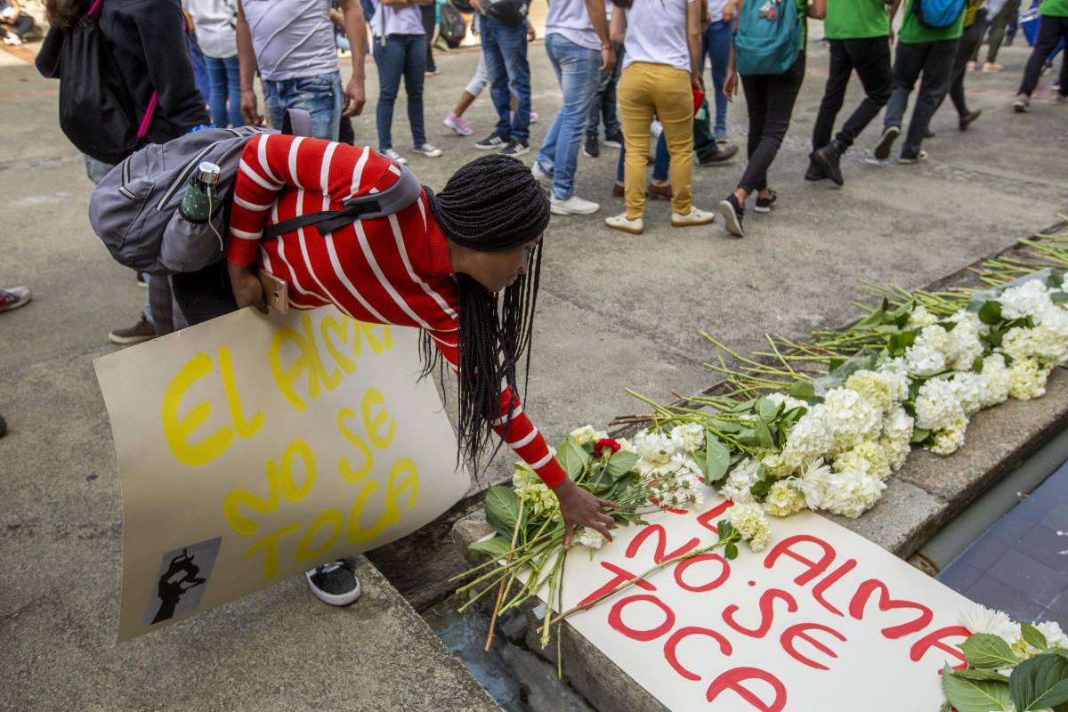 Flores y pancartas fueron llevados por la comunidad universitaria en un acto simbólico para rechazar los actos violentos.