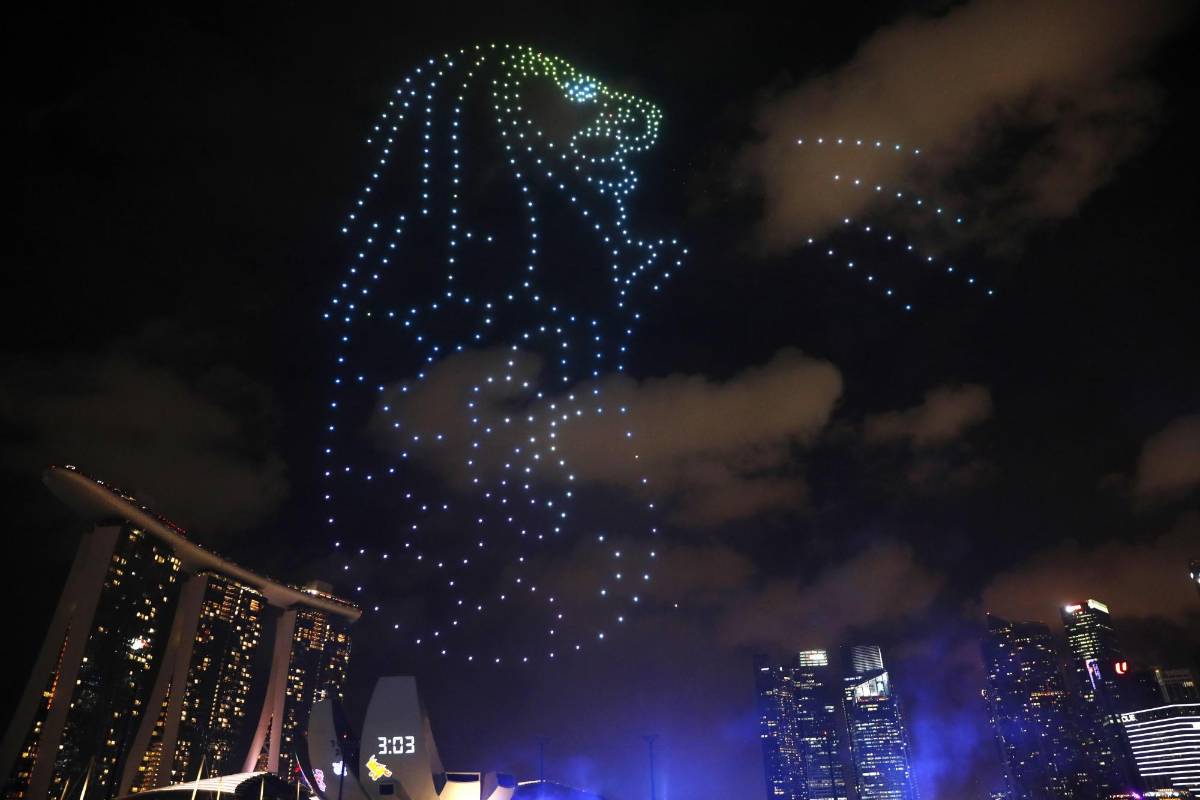 En Marina Bay en Singapur crearon figuras en el cielo, con drones, para darle la bienvenida. FOTO EFE