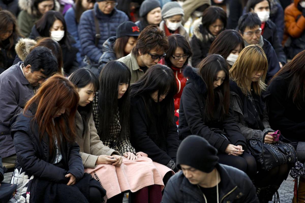 Pequeños grupos de sobrevivientes, abrigados contra el viento frío, se reunieron este miércoles en la costa nordeste de Japón para recordar las vidas perdidas en la tragedia. FOTO Reuters