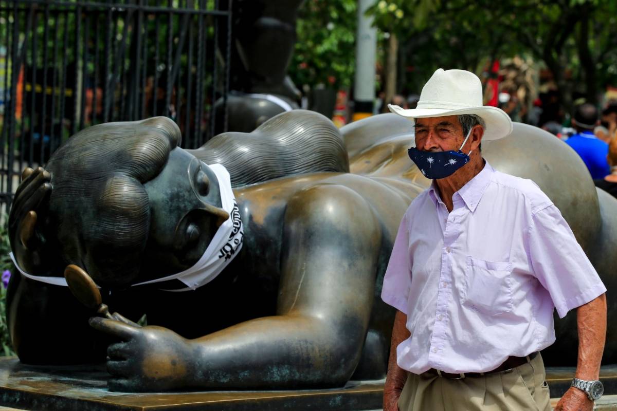 En la Plaza Botero, en inmediaciones del Museo de Antioquia, los rostros de las tradicionales figuras del maestro Fernando Botero fueron cubiertos con tapabocas. FOTO JAIME PÉREZ