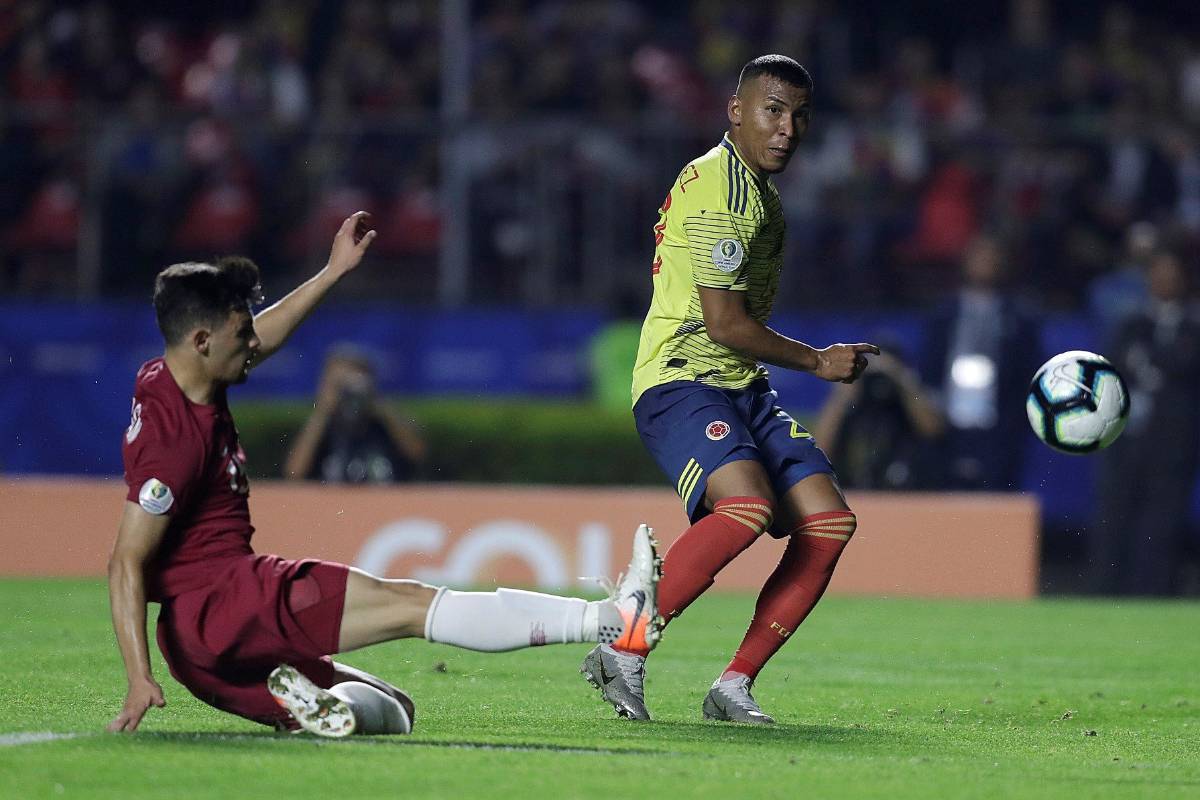 Roger Martínez disputa el balón con de Catar Bassam Alrawi durante el partido. FOTO EFE