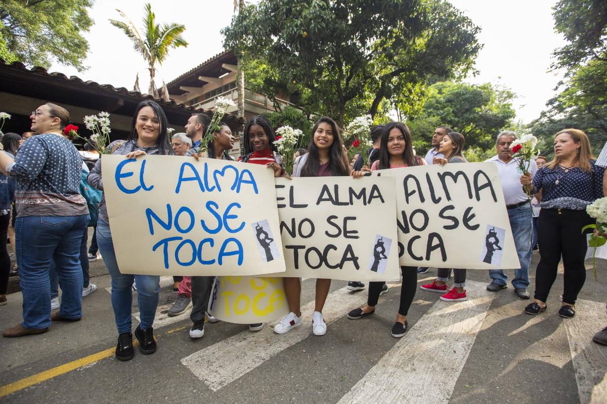 Flores y pancartas fueron llevados por la comunidad universitaria en un acto simbólico para rechazar los actos violentos.
