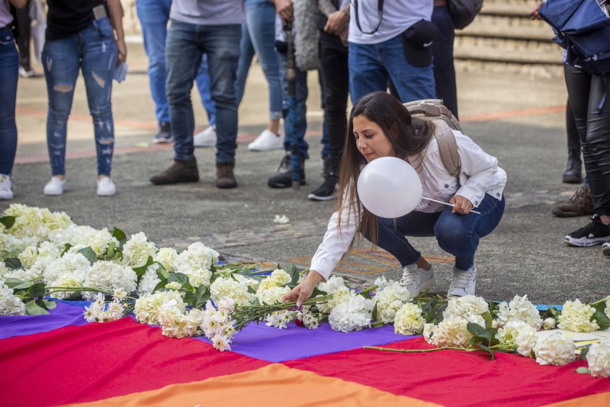Flores y pancartas fueron llevados por la comunidad universitaria en un acto simbólico para rechazar los actos violentos.