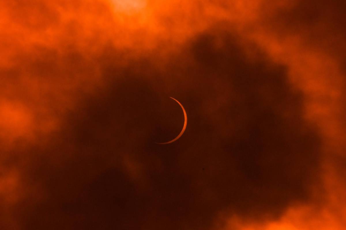 La luna se mueve frente al sol durante un eclipse solar anular visto a través de las nubes desde Nueva Delhi el 21 de junio de 2020. FOTO AFP