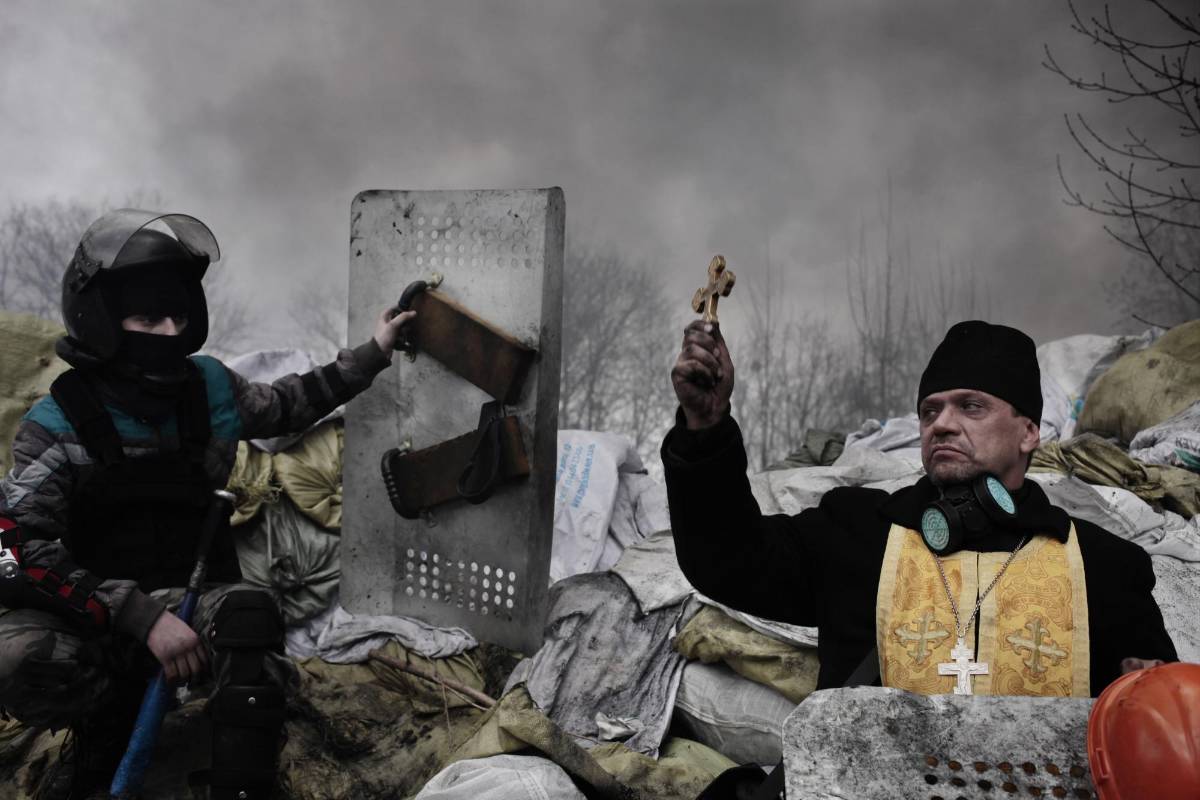 El fotógrafo francés Jerome Sessini, de la agencia Magnum ganó el segundo premio en la categoría de noticias de actualidad. Un sacerdote ortodoxo bendice a los manifestantes en una barricada en Kiev (Ucrania) el 20 de febrero de 2014. FOTO AP
