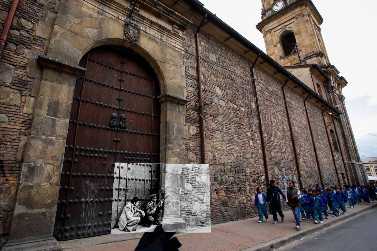 Un policía y un hombre de civil se resguardan al lado de una de las puertas sobre la calle 11 de la catedral Primada de Bogotá. FOTO Mauricio Alvarado- Colprensa