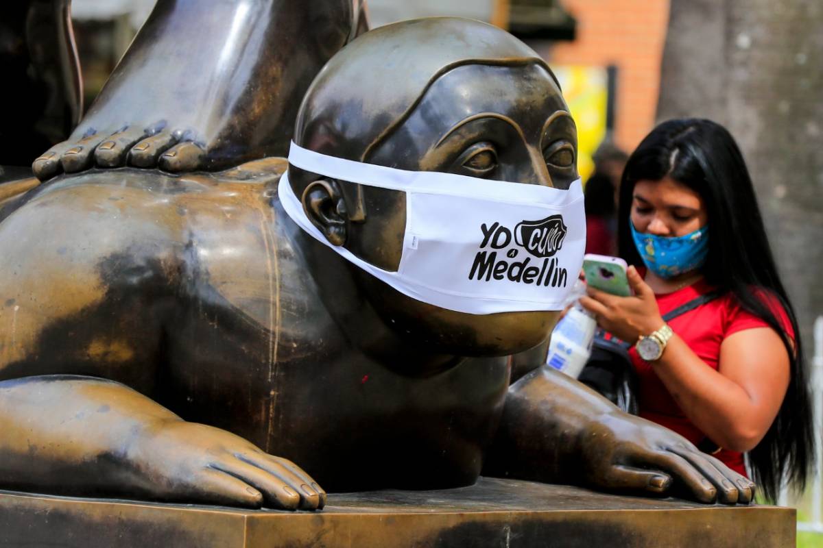 En la Plaza Botero, en inmediaciones del Museo de Antioquia, los rostros de las tradicionales figuras del maestro Fernando Botero fueron cubiertos con tapabocas. FOTO JAIME PÉREZ