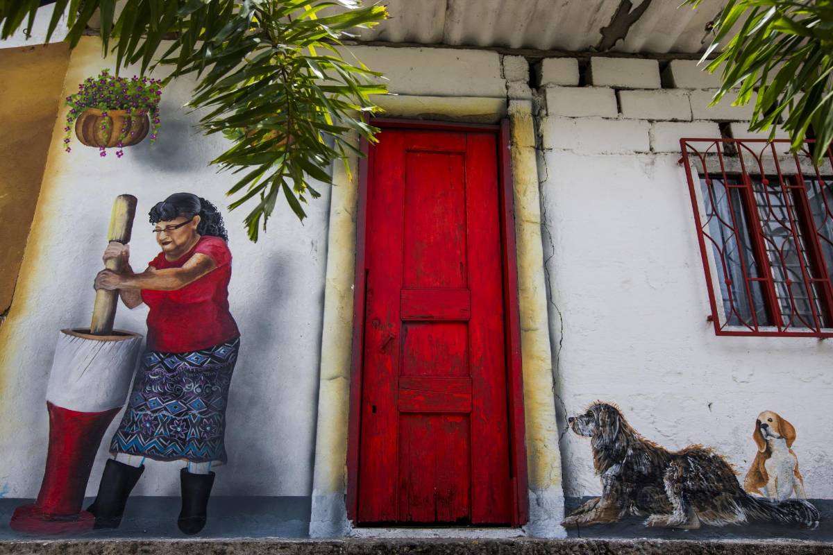 En esta pintura se ve como una señora está pilando maíz mientras desde una esquina su perro la mira vigilante. FOTO: JULIO CÉSAR HERRERA.