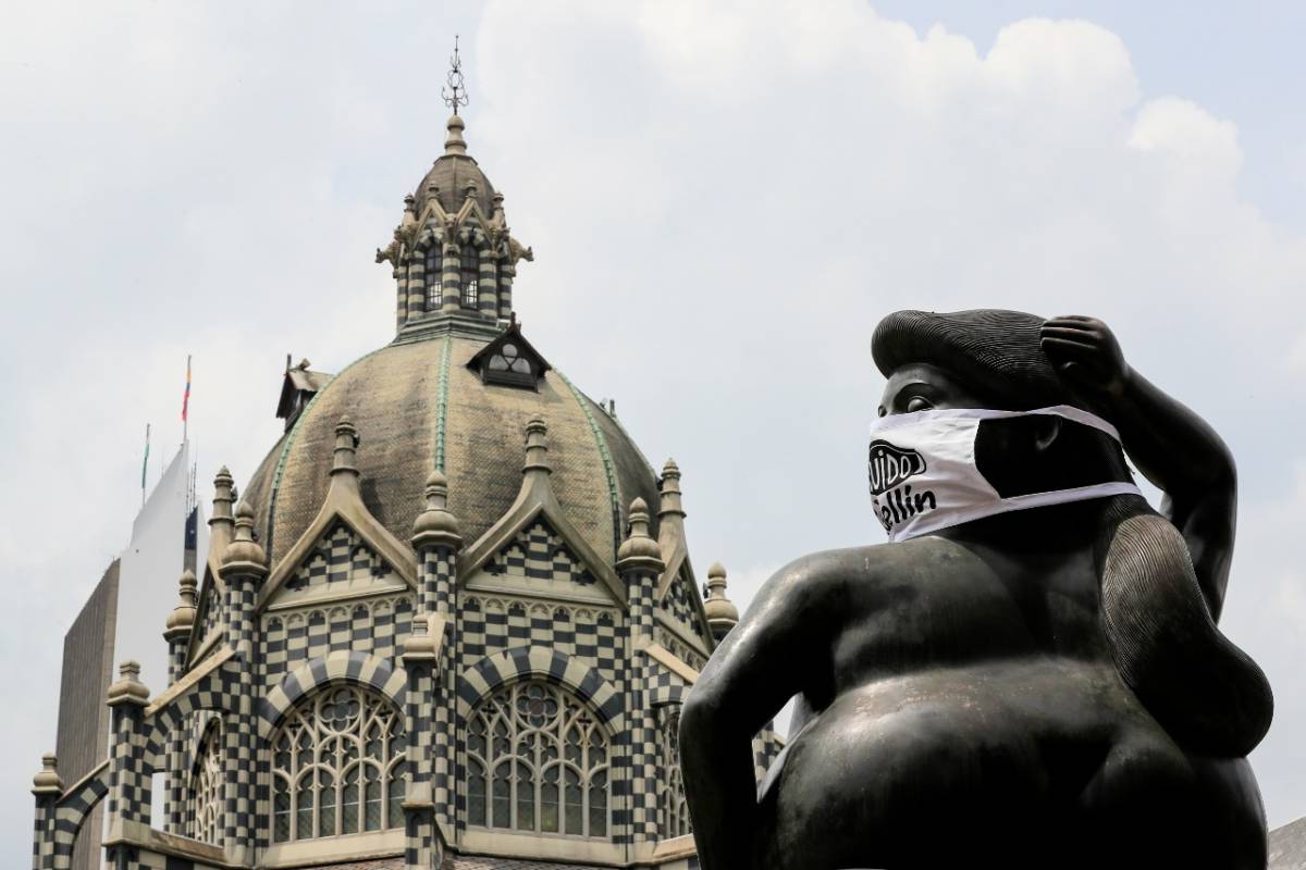 En la Plaza Botero, en inmediaciones del Museo de Antioquia, los rostros de las tradicionales figuras del maestro Fernando Botero fueron cubiertos con tapabocas. FOTO JAIME PÉREZ