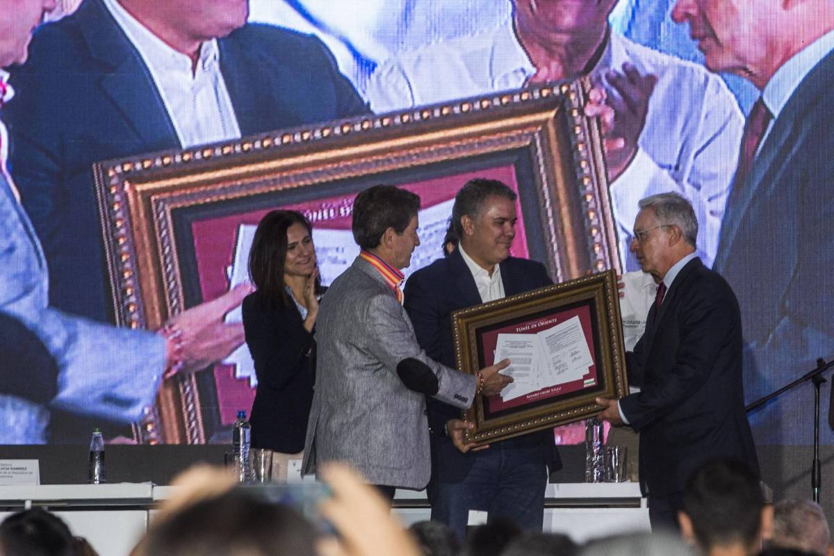 El presidente Iván Duque entrega junto al gobernador de Antioquia, Luis Perez, el primer contrato para la construcción del túnel de Oriente al senador Álvaro Uribe Vélez. FOTO Julio César Herrera 