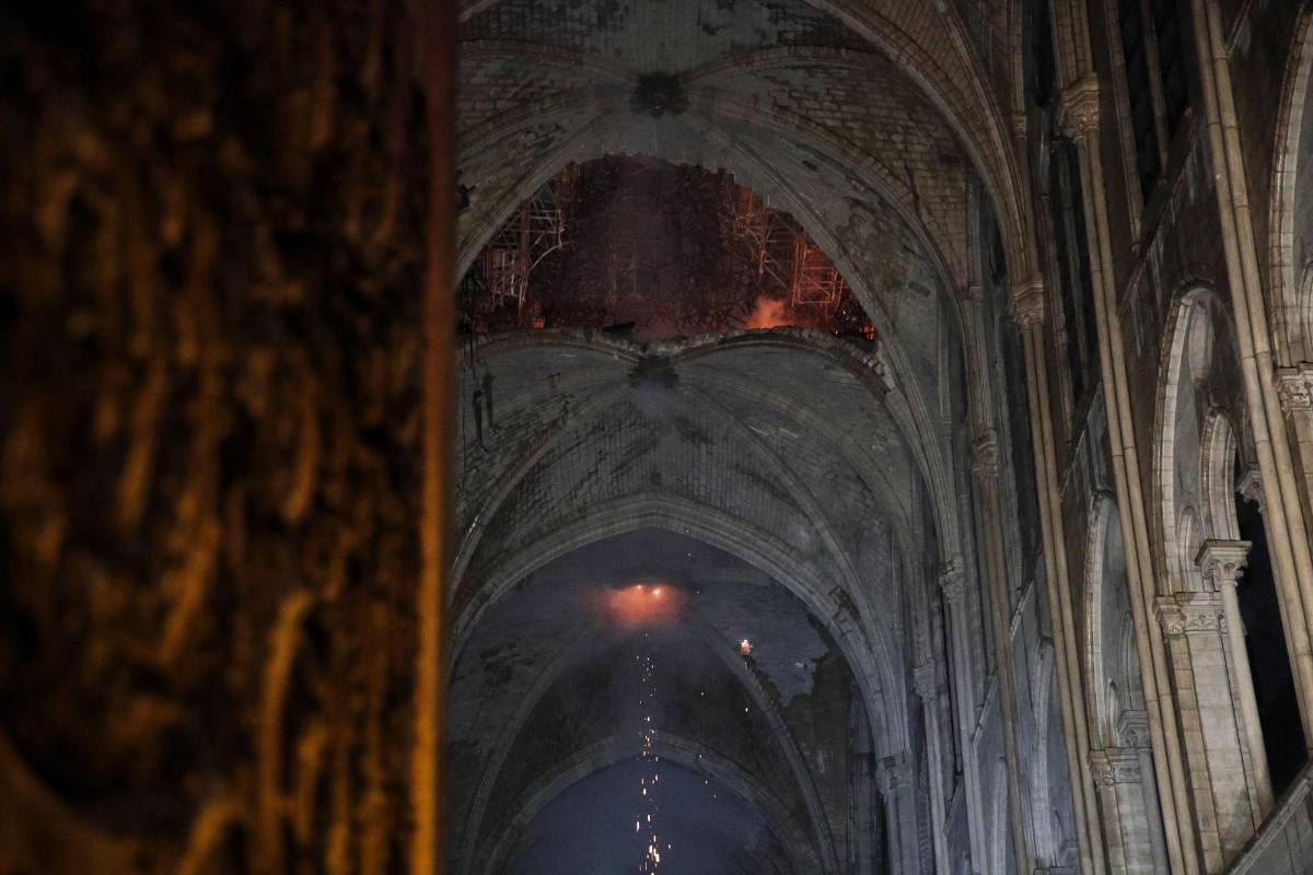 “Todo estaba oscuro, pero en el fondo seguía de pie la gran cruz del altar, iluminada por las llamas. ¡Fue impresionante”, describe este vicario que pasó toda la noche en vela junto a su queridísima iglesia. FOTO EFE