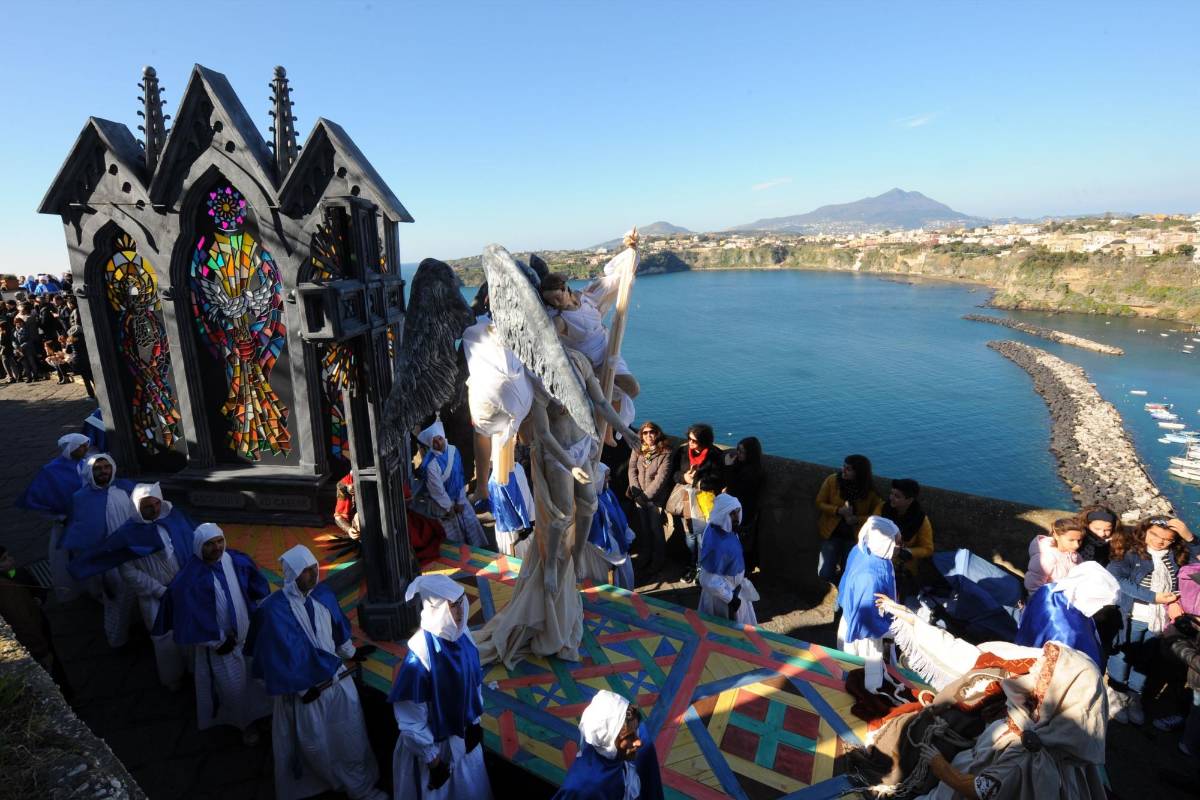 Varios fieles de la iglesia católica sostienen el paso llamado Ángeles durante la procesión de crucifixión y resurrección de este viernes santo en la isla de Procida en Nápoles (Italia). FOTO AFP