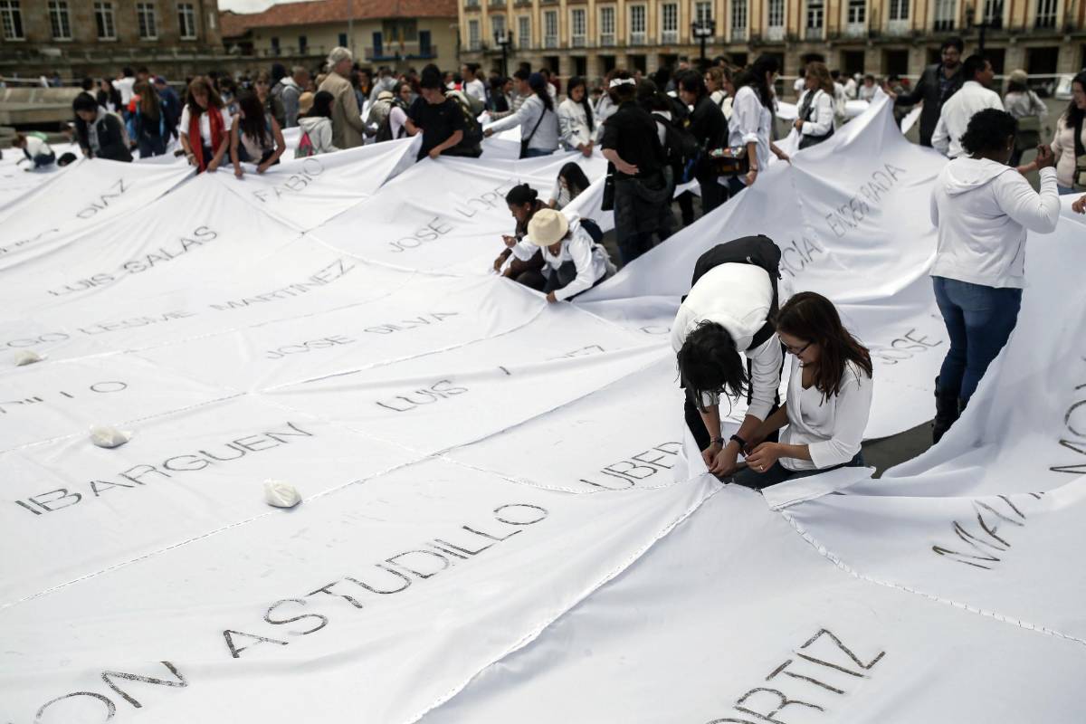 En dos días escribieron con ceniza 1900 nombres de secuestrados, desaparecidos, falsos positivos, asesinados, víctimas, en 7000 metros de tela blanca. FOTO AP