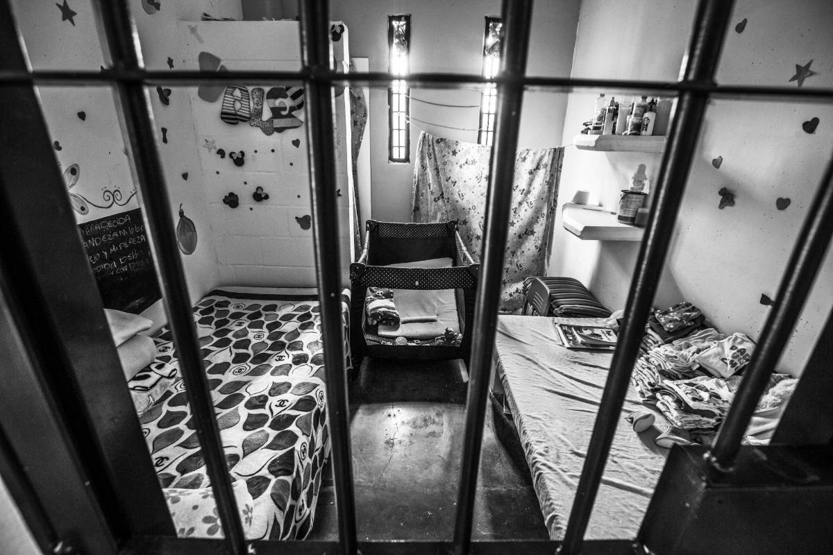 Tras las rejas, la vida de madres e hijos continua entre juegos, ropa, dibujos y un espacio aproximadamente de siete metros de largo por cinco de ancho que los separa de la sociedad. Para las madres es un encierro mientras pagan su condena, para los niños un espacio donde las risas y los juegos es el acto más liberador. Foto: Manuel Saldarriaga Quintero.
