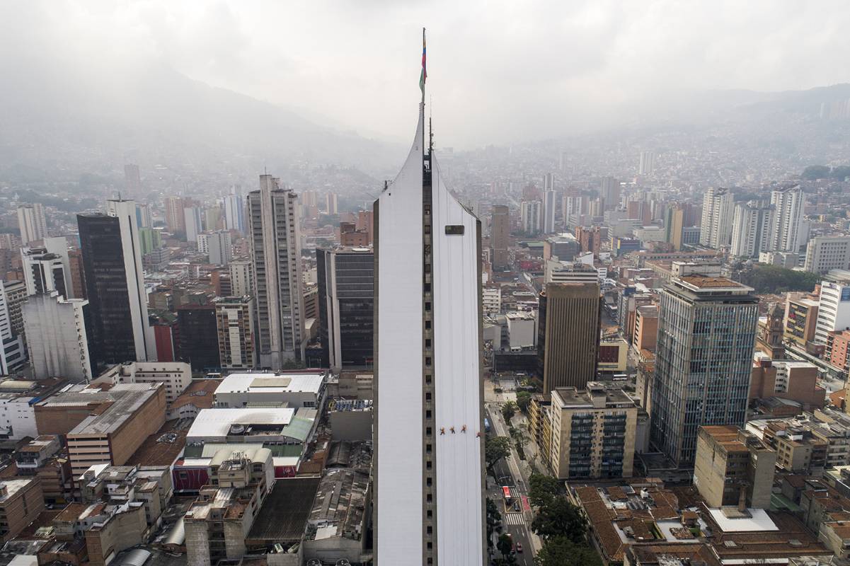 Los obreros desafían la gravedad para darle una mano de pintura al edificio. Esteban Vanegas