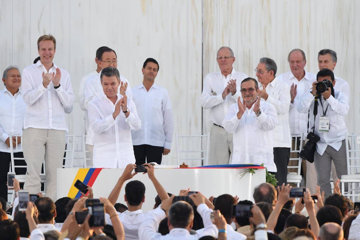 El presidente Juan Manuel Santos y el comandante de las Farc, Rodrigo Londoño, firmaron los acuerdos con los cuales buscan poner fin a más de medio siglo de conflicto armado en Colombia. FOTO AFP