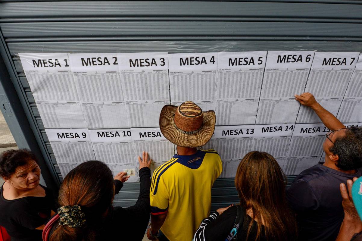 Las imágenes que dejan las primeras cuatro horas de votación son de pocos votantes en la mayoría de las 81.925 mesas distribuidas en 11.034 puestos de votación de todo el país, o de votantes guarecidos bajo paraguas. FOTO AFP
