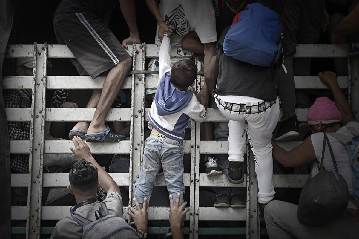 Los migrantes venezolanos suben a un camión en la carretera de Cúcuta a Pamplona. FOTO AFP