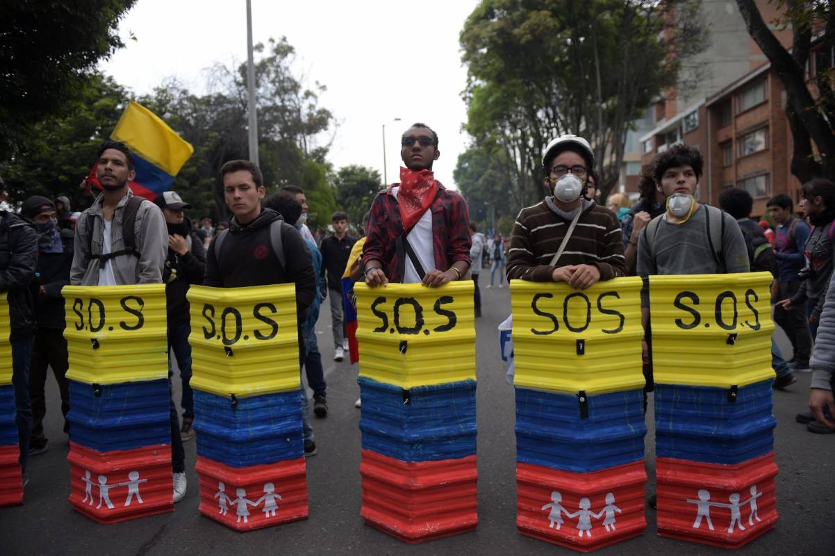 La sede de RCN Radio, en Bogotá, que en las anteriores jornadas fue objeto de ataques por manifestantes, fue rodeada con una bandera de Colombia, como una invitación a que esos hechos no se repitan. Foto: AFP