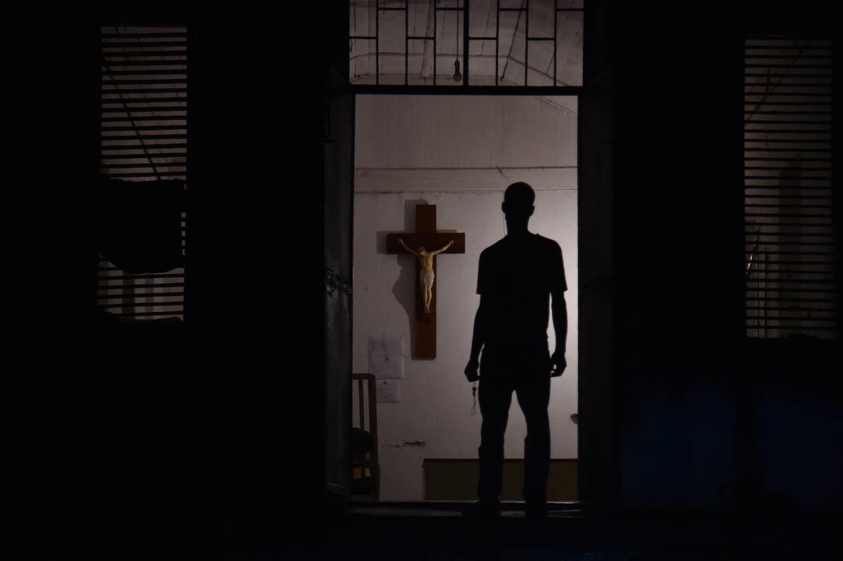 Silueta de un hombre joven mientras está parado en la puerta de una iglesia en el Hospital de la Inmaculada Concepción en Port-de-Paix, Haití. Foto AFP