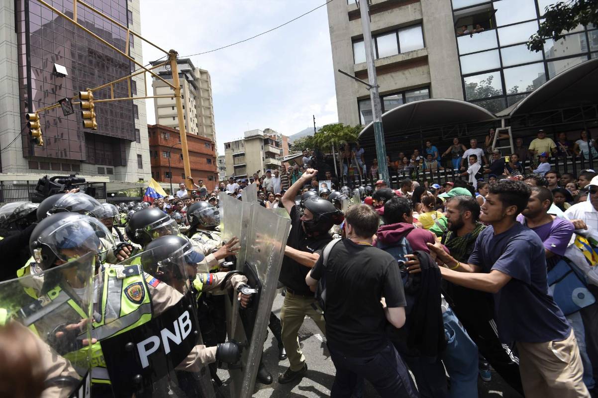 Venezolanos se enfrentan a las autoridades de Caracas durante las protestas. FOTO AFP