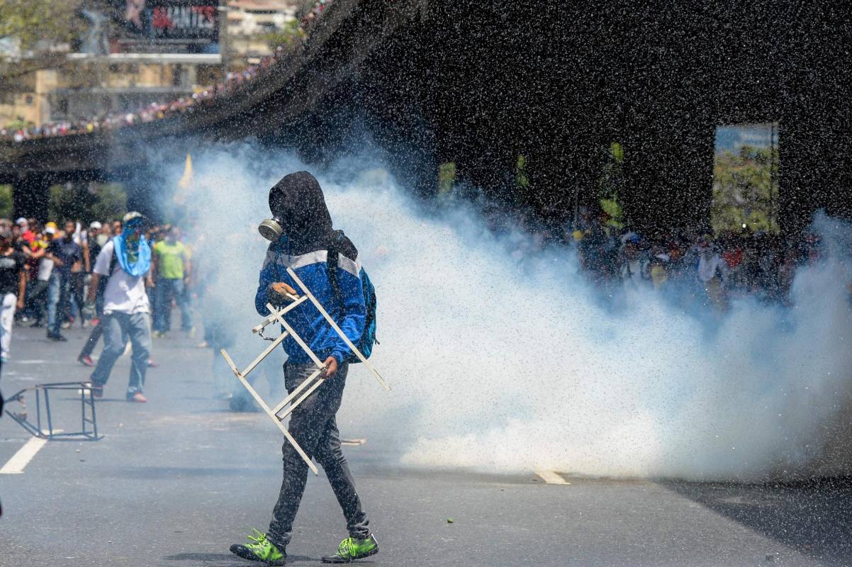 Los enfrentamientos cumplieron una hora, tiempo durante el que algunos de los manifestantes, casi todos usando capuchas, armaron barricadas. FOTO AFP