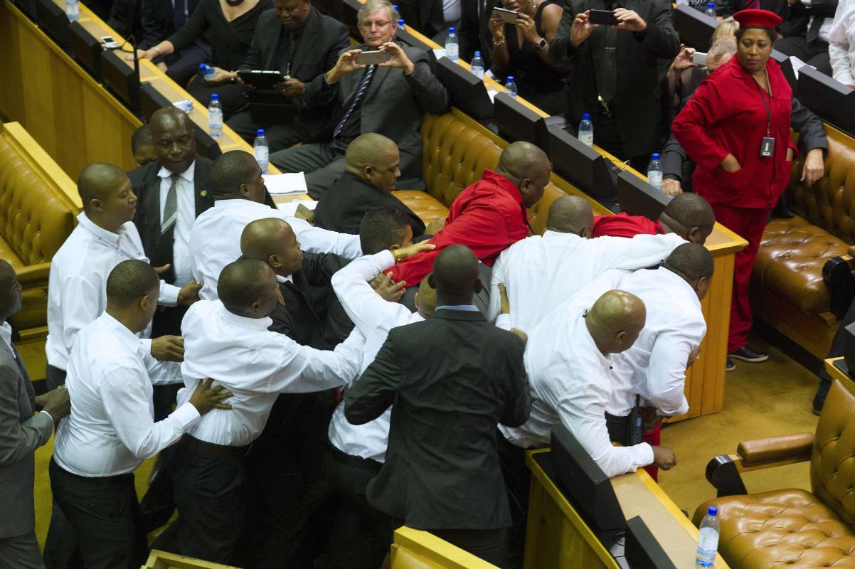 Fuerzas de seguridad fueron llamados para expulsar a los legisladores radicales que interrumpieron al presidente de Sudáfrica, Jacob Zuma frente al Parlamento. FOTO AFP