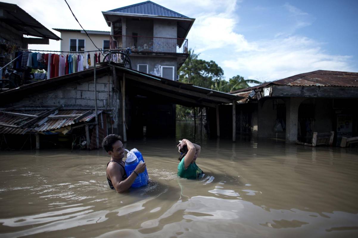  Los residentes caminan a través de una calle inundada después del Súper Tifón Mangkhut en Calumpit, Filipinas. Foto: AFP