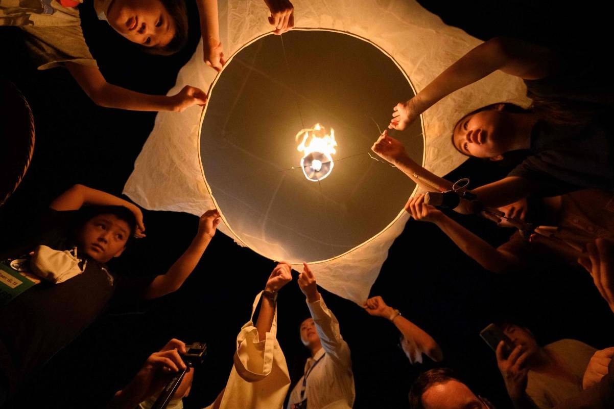 Miles de personas se reúnen cada noviembre para hacer ofrendas florales y de globos de luz bajo la tradición del budismo que se vive en Tailandia, la mayoría de los participantes empezaron siendo agricultores, pero ahora llegan muchos turistas y residentes del país por el colorido de la celebración. Foto: Mladen Antonov, Agencia AFP