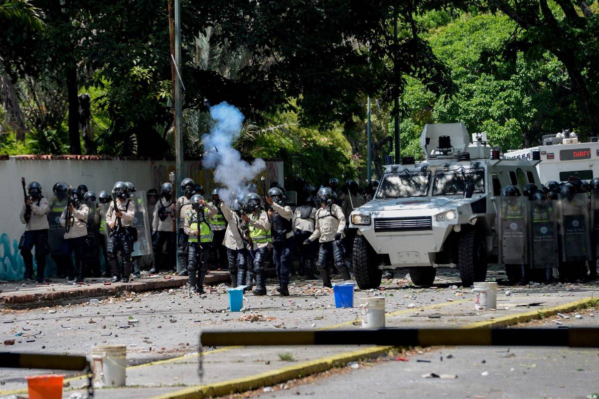 Agentes de la Guardia Nacional y Policía disparan gases lacrimógenos a manifestantes de la oposición. AFP