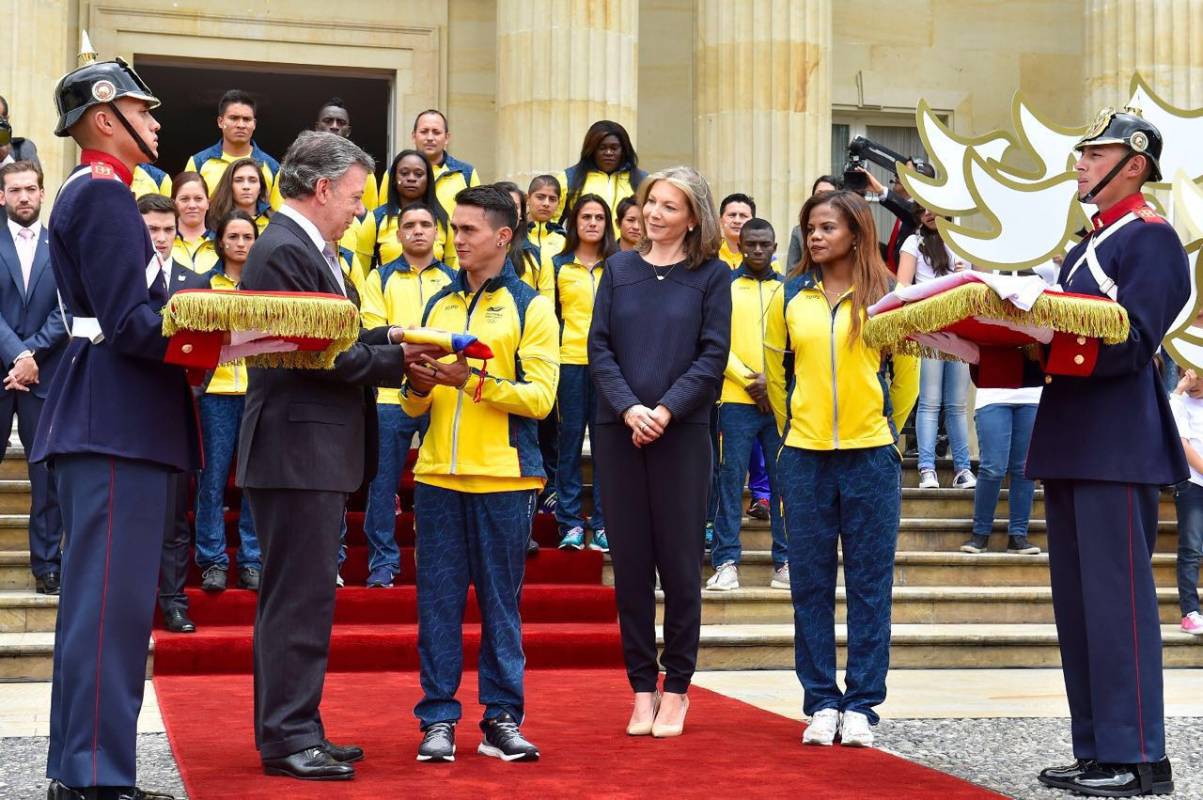 El gimnasta Jossimar Calvo, quien fue elegido para se el abanderado, fue el encargado de recibir de las manos del presidente el pabellón nacional. Foto Cortesía Presidencia