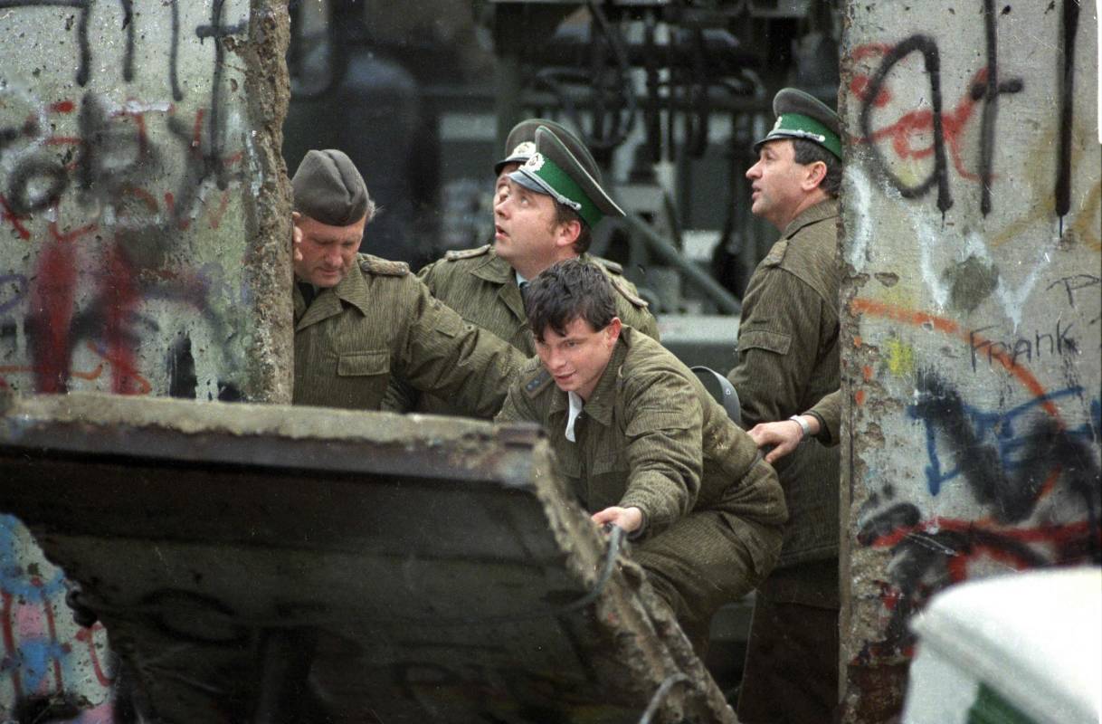 Guardias fronterizos de Alemania Oriental arreglan una sección del muro entre el este y el oeste de Berlín. Foto de archivo. FOTO AFP