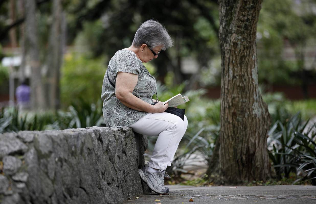 En medio de la agitada rutina de la ciudad, lectores espontáneos aprovechan un momento de calma para leer un buen libro. Foto: Manuel Saldarriaga.